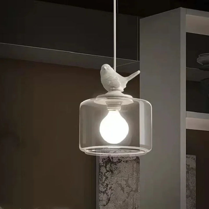 Dekoracyjna lampa wisząca z kloszem szklanym i figurką ptaka