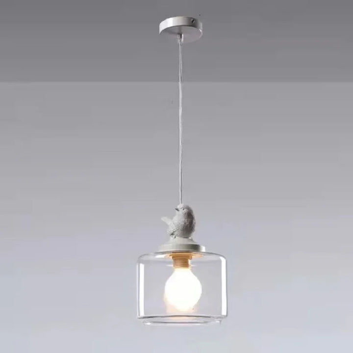 Dekoracyjna lampa wisząca z kloszem szklanym i figurką ptaka