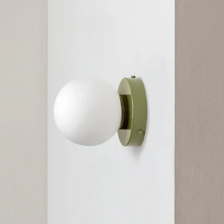 Kinkiet z mleczną szklaną kulą na okrągłej podstawie