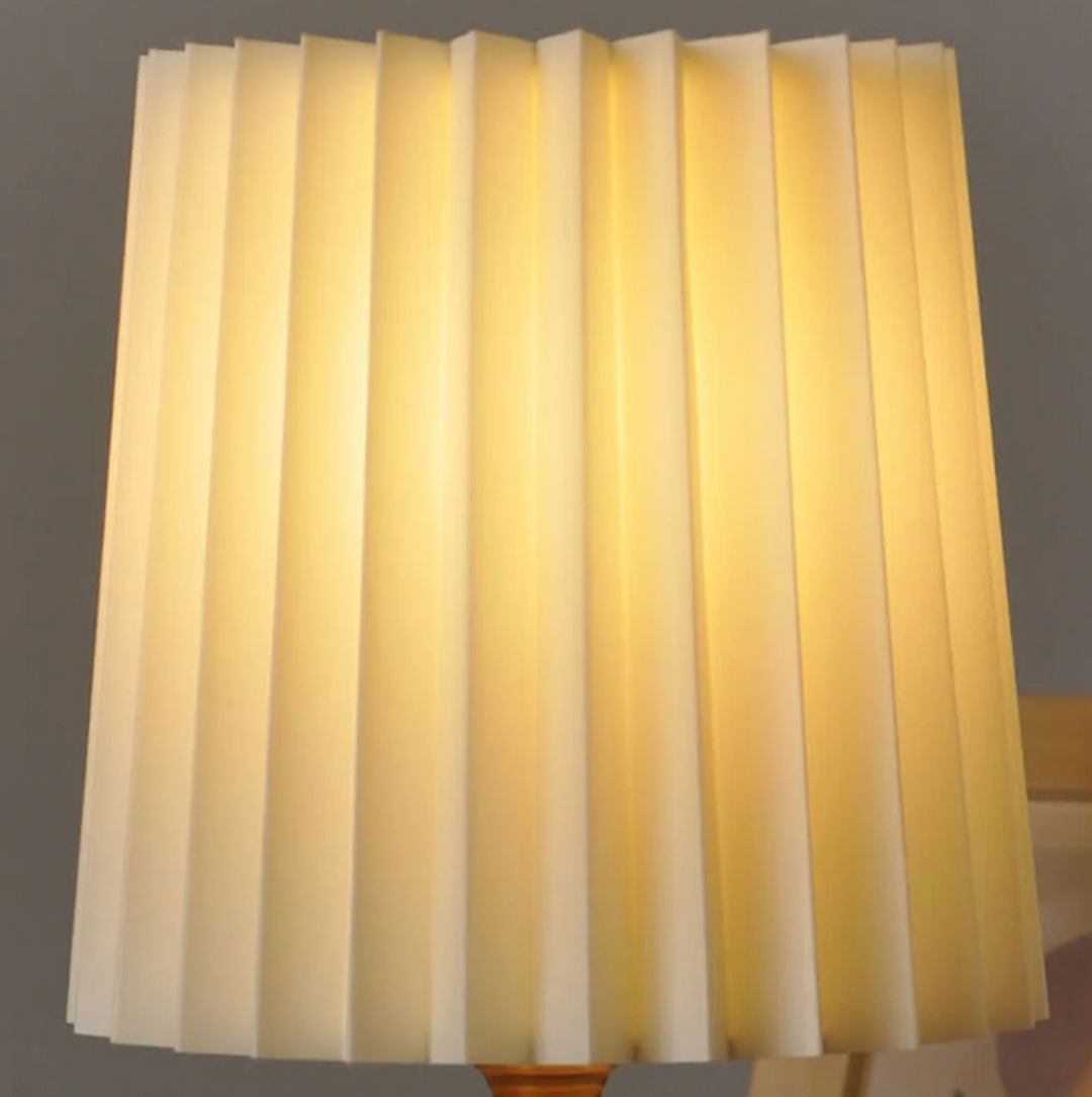 Lampa stołowa z drewnianą podstawą i plisowanym kloszem