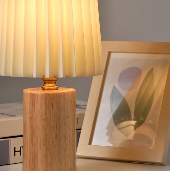 Lampa stołowa z drewnianą podstawą i plisowanym kloszem