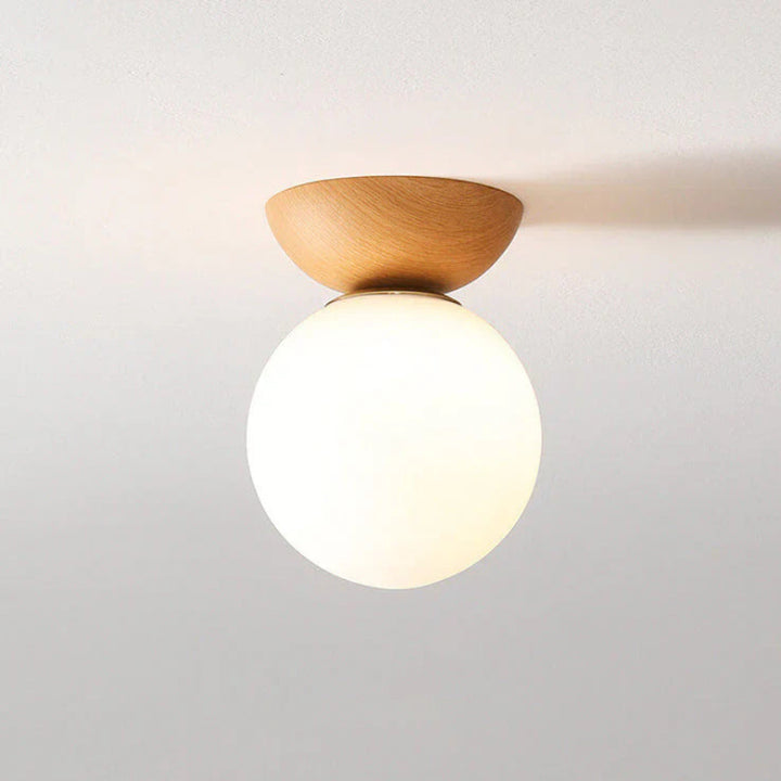 Lampa sufitowa z drewnianą podstawą i matową kulą