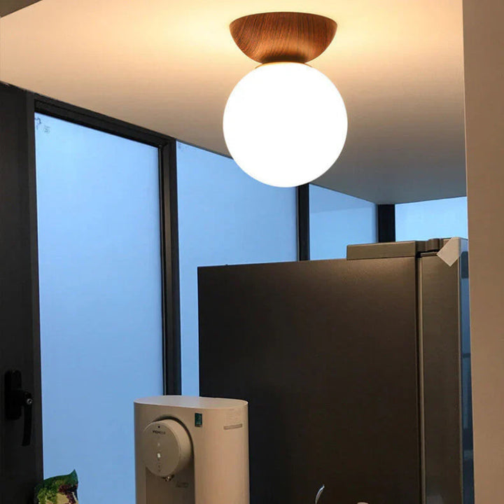Lampa sufitowa z drewnianą podstawą i matową kulą