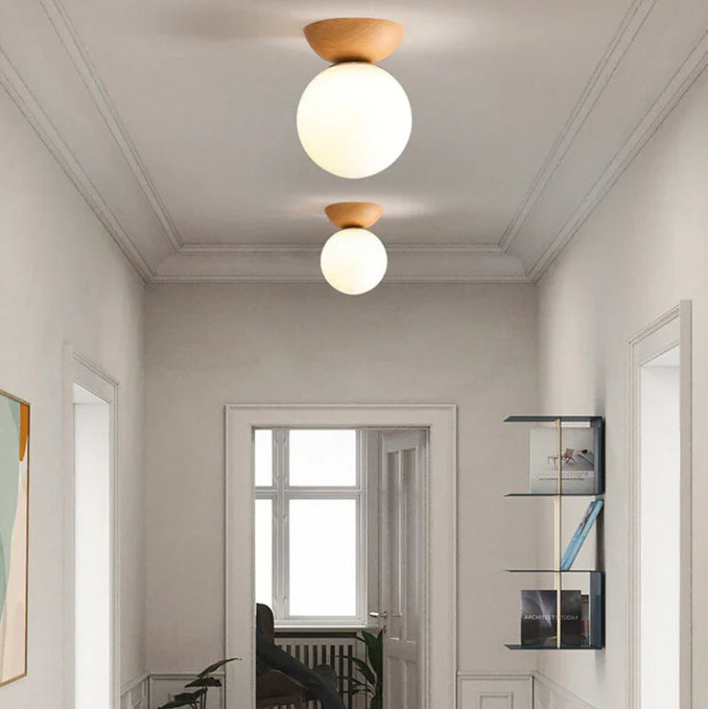 Lampa sufitowa z drewnianą podstawą i matową kulą