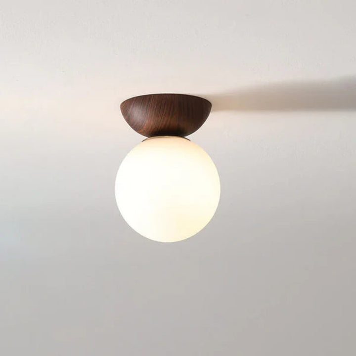 Lampa sufitowa z drewnianą podstawą i matową kulą