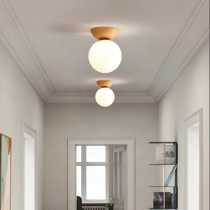 Lampa sufitowa z drewnianą podstawą i matową kulą