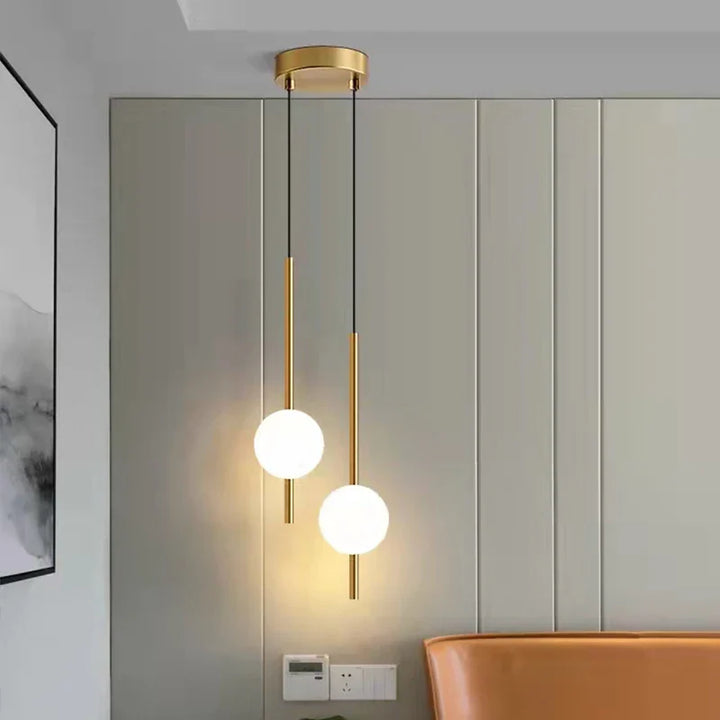 Lampa wisząca LED ze szklaną kulą na złotym trzonie rurowym