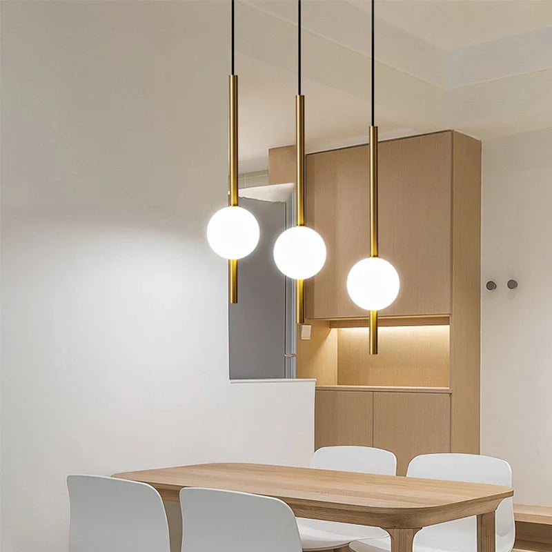 Lampa wisząca LED ze szklaną kulą na złotym trzonie rurowym
