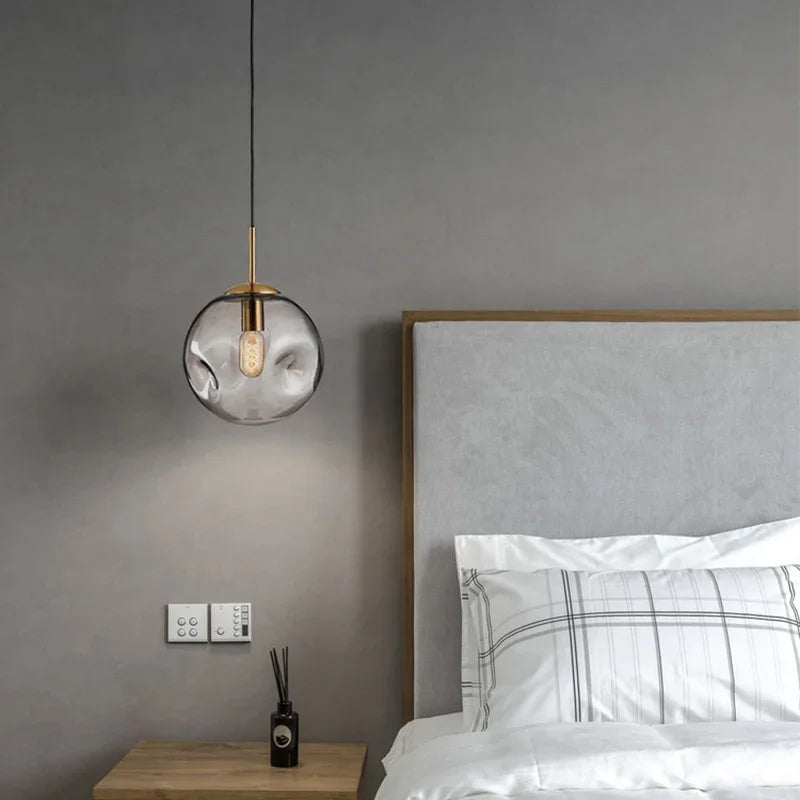 Lampa wisząca w kształcie szklanej kuli z nieregularnie teksturowanym kloszem i żarówką Edisona