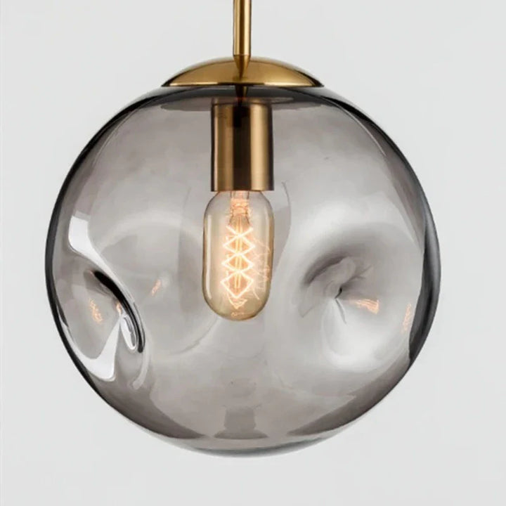 Lampa wisząca w kształcie szklanej kuli z nieregularnie teksturowanym kloszem i żarówką Edisona