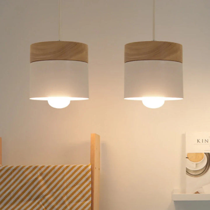 Lampa wisząca z cylindrycznym metalowym kloszem i drewnianą nakładką