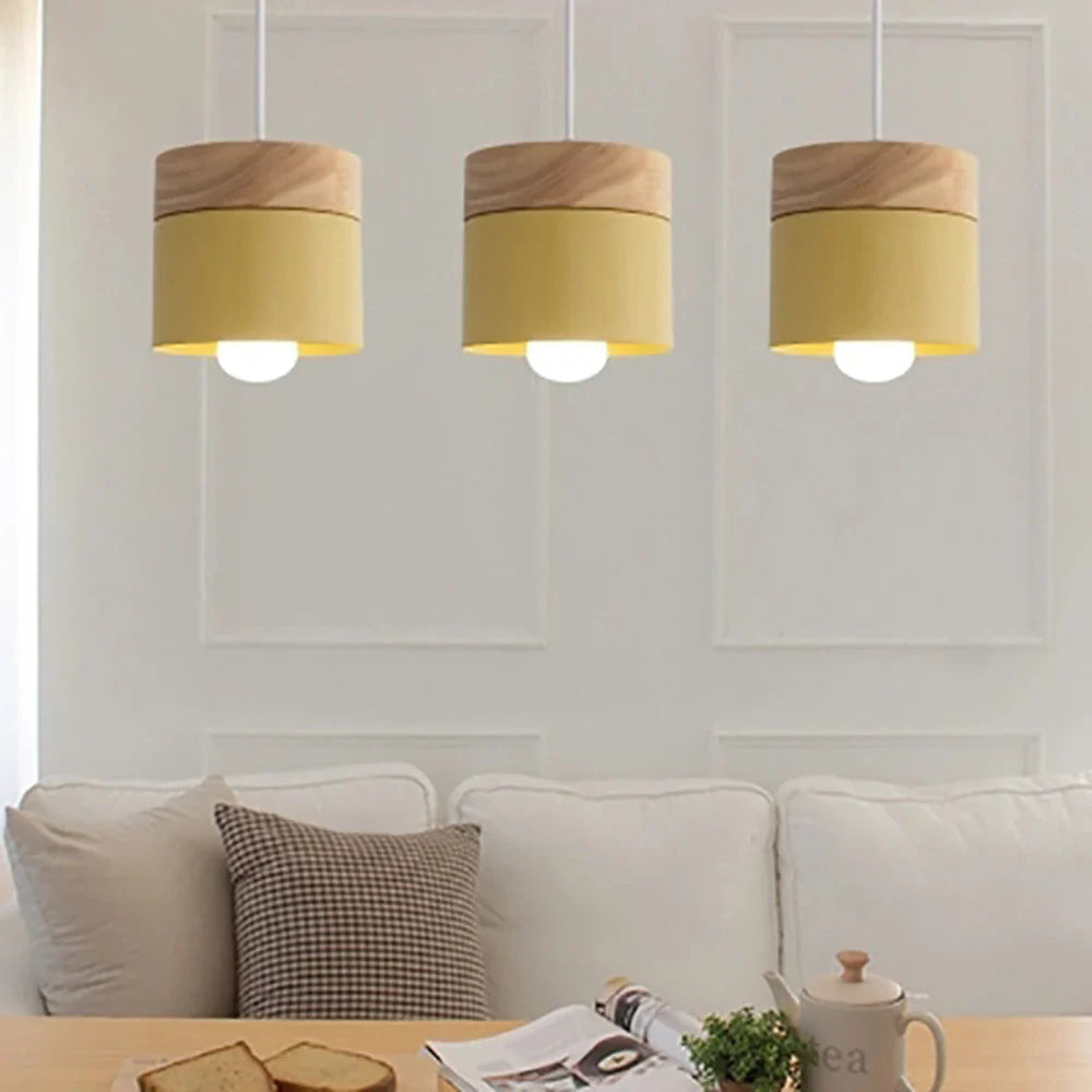 Lampa wisząca z cylindrycznym metalowym kloszem i drewnianą nakładką