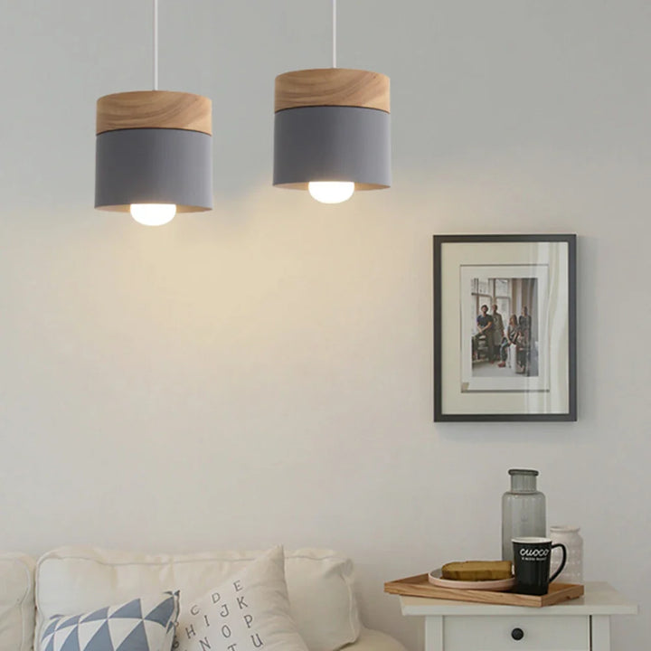 Lampa wisząca z cylindrycznym metalowym kloszem i drewnianą nakładką