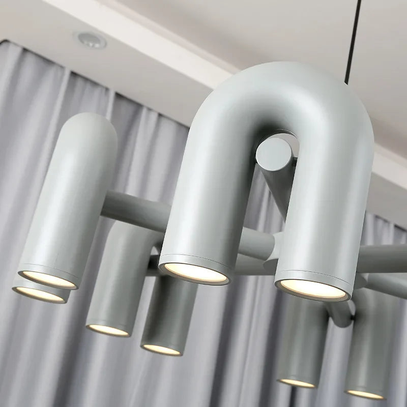 Lampa wisząca z cylindrycznymi punktami świetlnymi na łukowatych ramionach