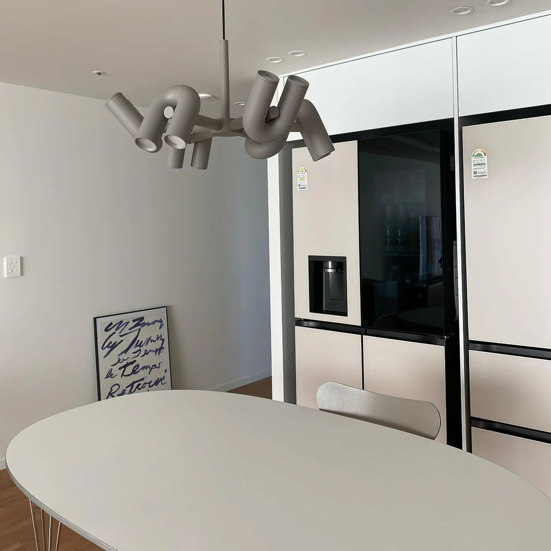 Lampa wisząca z cylindrycznymi punktami świetlnymi na łukowatych ramionach