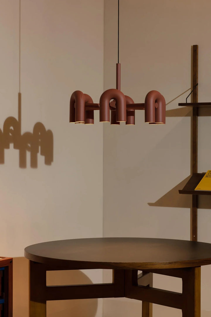 Lampa wisząca z cylindrycznymi punktami świetlnymi na łukowatych ramionach