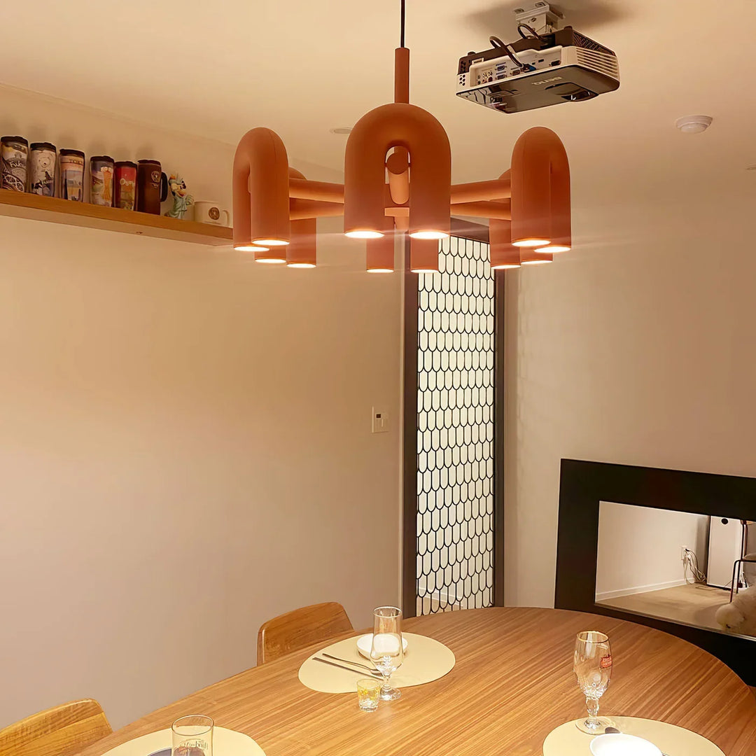 Lampa wisząca z cylindrycznymi punktami świetlnymi na łukowatych ramionach