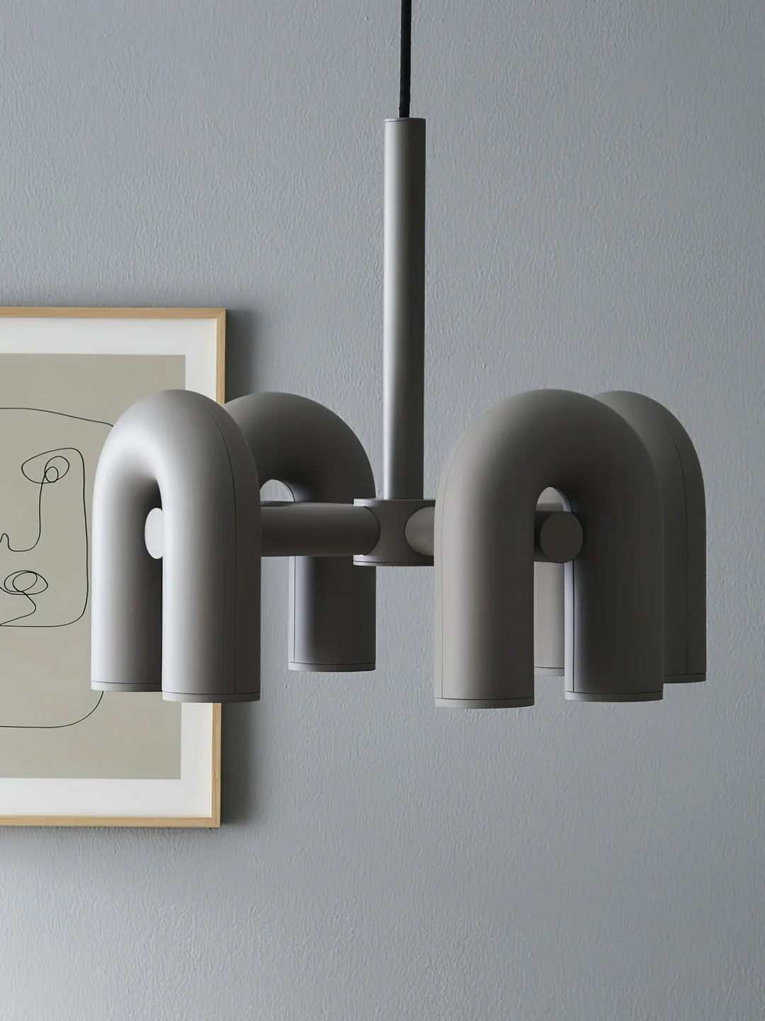 Lampa wisząca z cylindrycznymi punktami świetlnymi na łukowatych ramionach