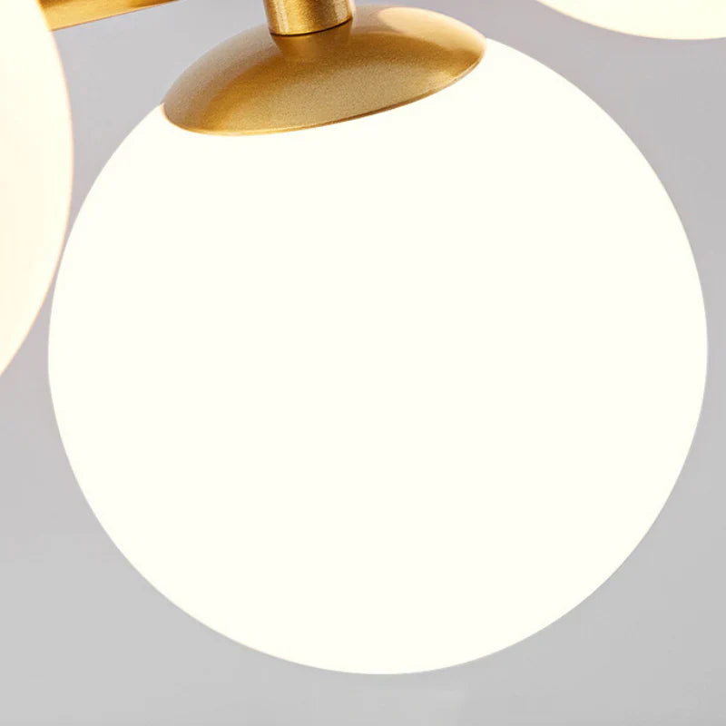 Lampa wisząca z poziomym ramieniem i kulistymi szklanymi kloszami