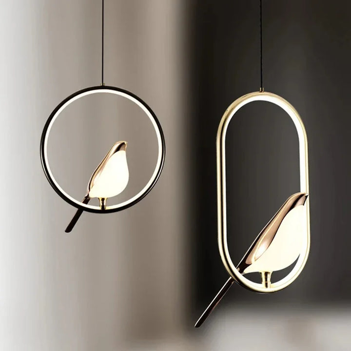 Wisząca lampa LED z okrągłym, świecącym pierścieniem i złotą figurką ptaka na grzędzie