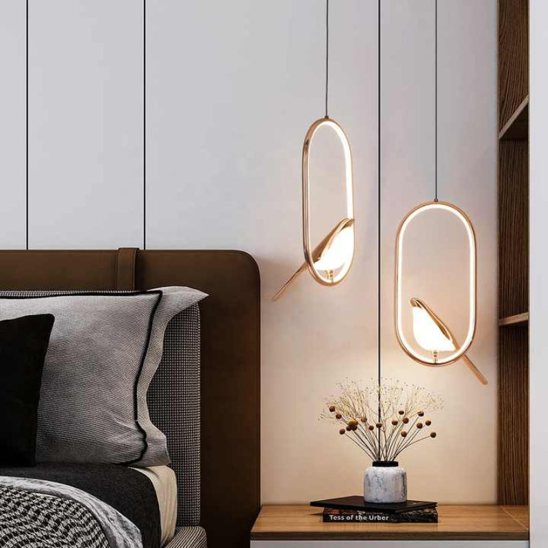 Wisząca lampa LED z okrągłym, świecącym pierścieniem i złotą figurką ptaka na grzędzie